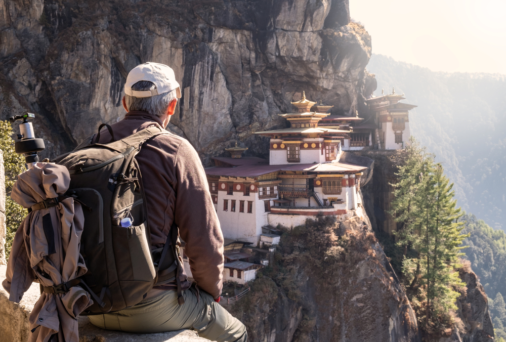 Tourist sitting on his back, watching Tiger`s Nest Temple in Paro, Bhutan