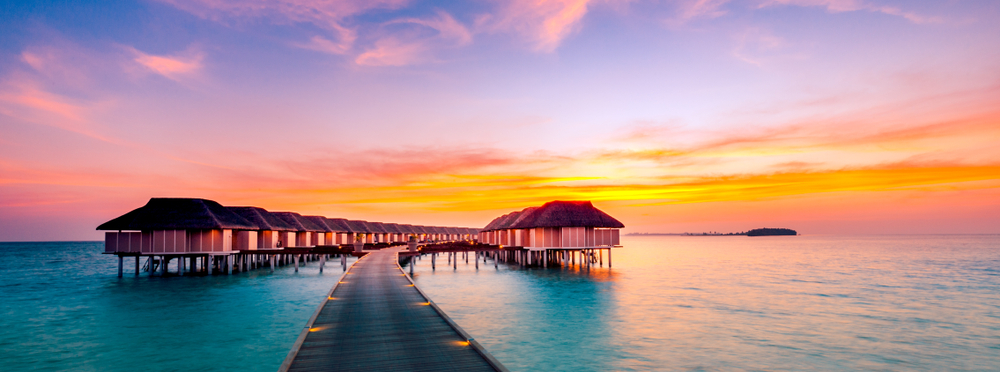 Amazing sunset panorama at Maldives. Luxury resort villas seascape