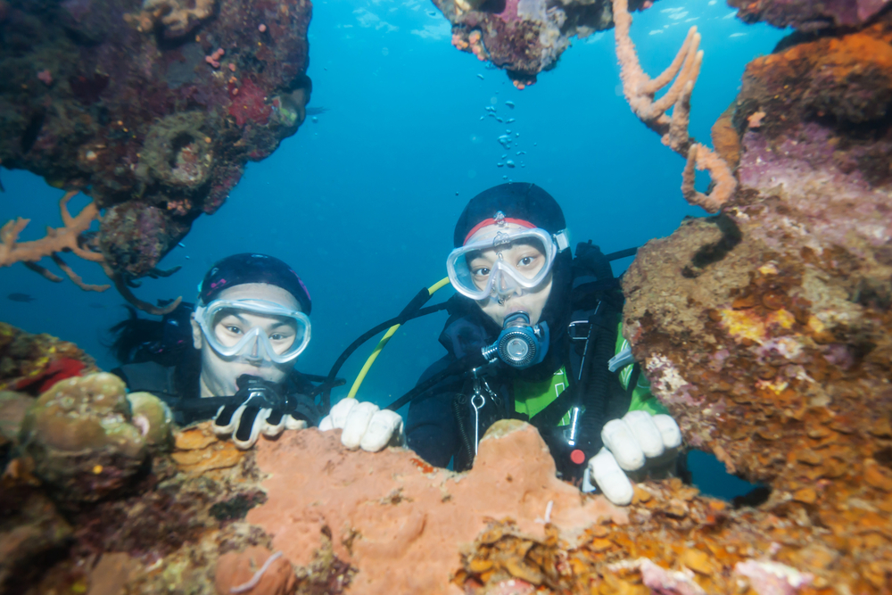 Scuba diver exploring world war II shipwreck in Coron area, Palawan, Philippines.