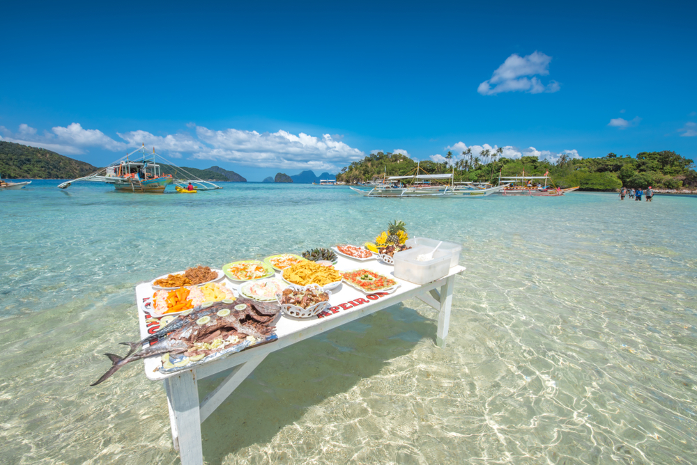 El Nido, Palawan, Philippines.A Feast of Lunch with Fruits and Barbeque Food During Island Hopping Tours in El Nido, the Philippines 