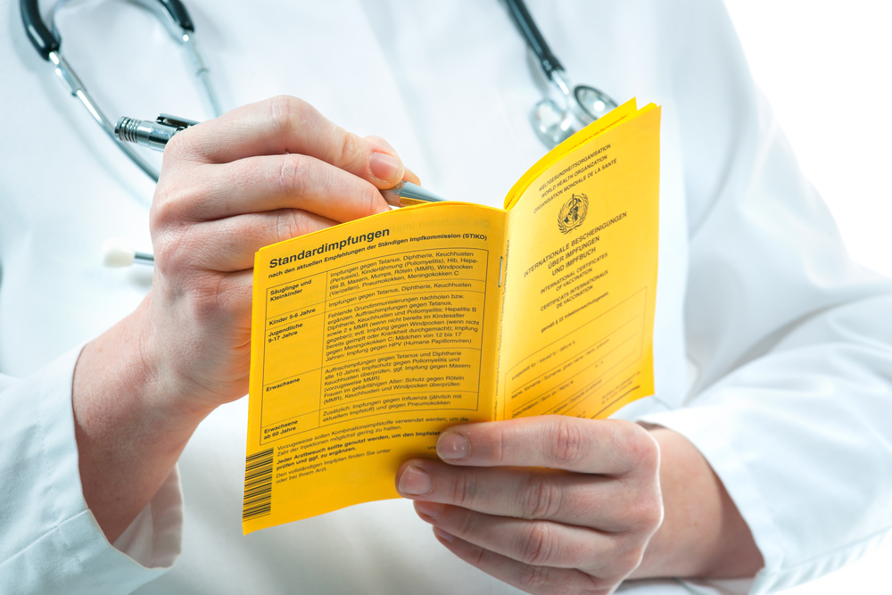 Doctor is filling out an international certificate of the vaccination