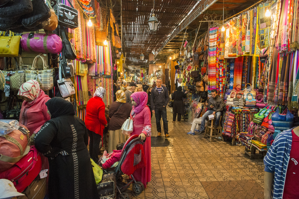 People walking on a corridor surrounded by booths and stalls in Jemma Dar Fna, Marrakech, Morocco