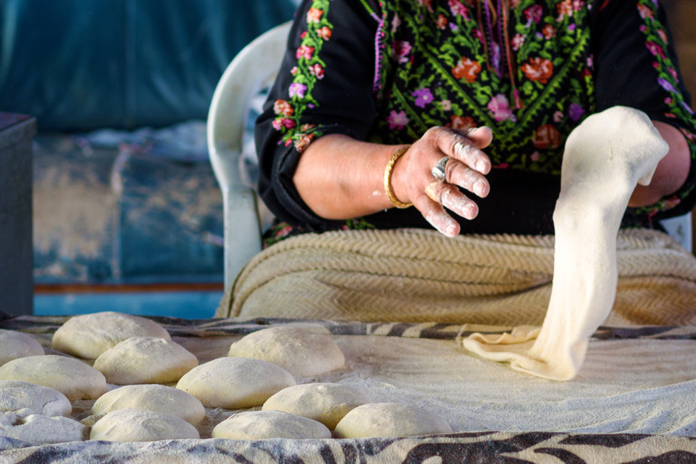 woman hands kneading fresh dough for Taboon bread or Lafah is a Middle Eastern flatbread