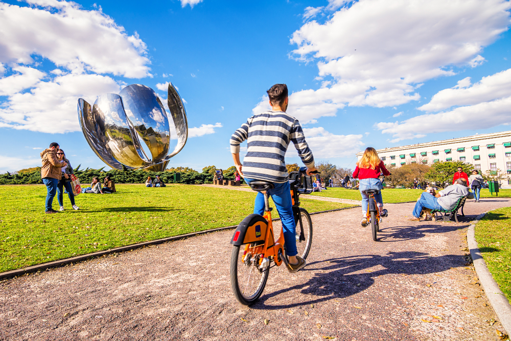 People doing Outdoor Activities on a Beautiful Sunny Day with Blue Sky near famous Metal Structure Floralis Generica in Plaza de Naciones Unidas, Recoleta