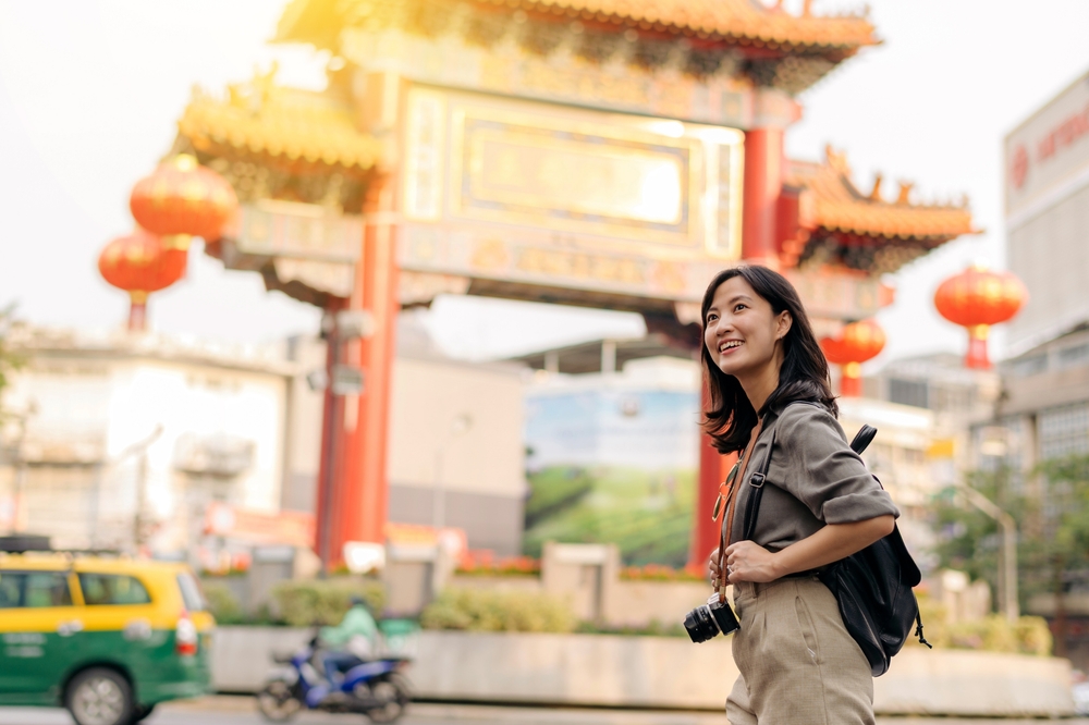 Young Asian woman backpack traveler enjoying China town in Bangkok, Thailand. Journey trip lifestyle, world travel explorer or Asia summer tourism concept.