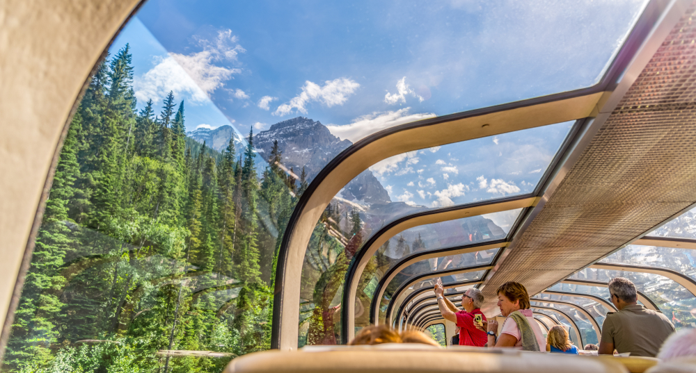 Rocky Mountaineer train traveling through the Rocky Mountains with luxury dining on board