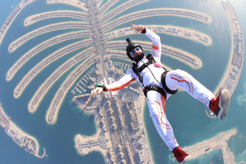 Tourism air beach jump. Freedom as a way of life. Parachutist performs an acrobatic trick in the Dubai air tourism.
