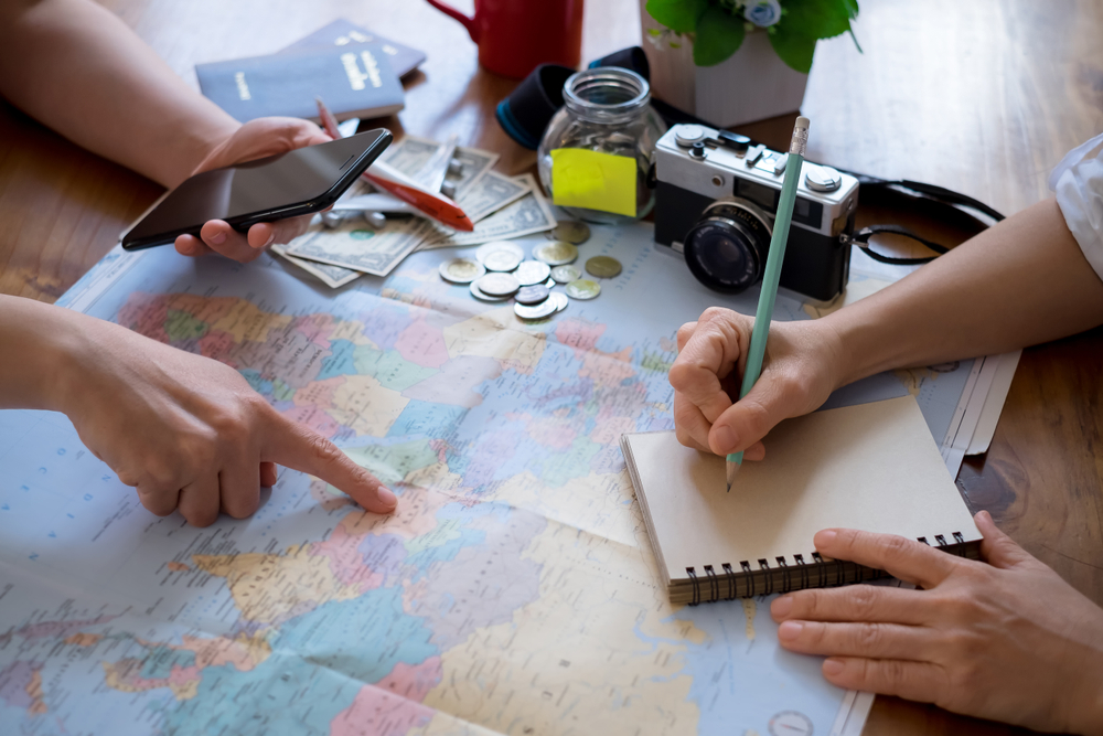 Young couple planning honeymoon vacation trip with map.