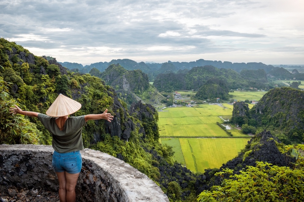 Tourist with outstretched arms in Ninh Binh, Vietnam. Happy tourist in Vietnam.