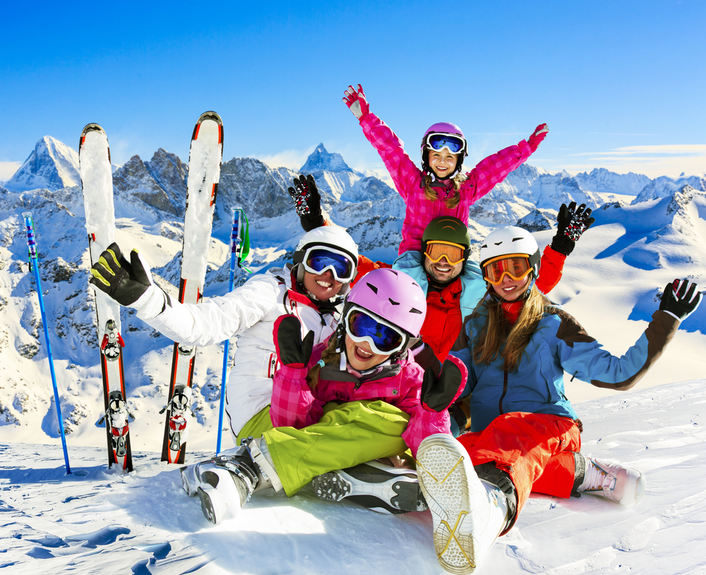 Skiing family enjoying winter vacation on snow in sunny cold day in mountains and fun. Switzerland, Alps.