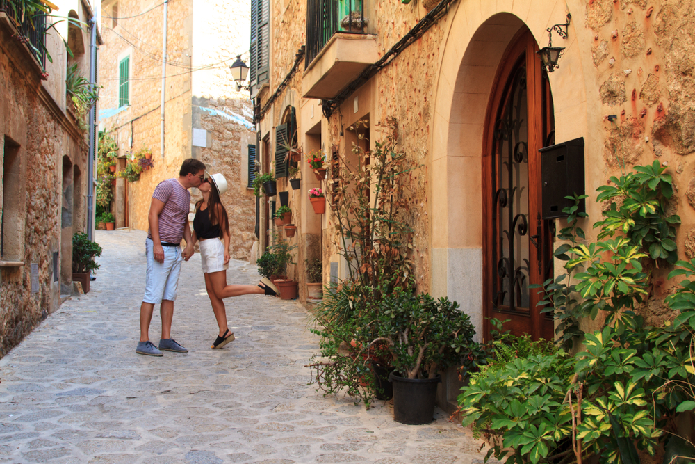 Young couple is kissing on Valldemossa street, Mallorca island, Balearic Islands, Spain, honeymoon