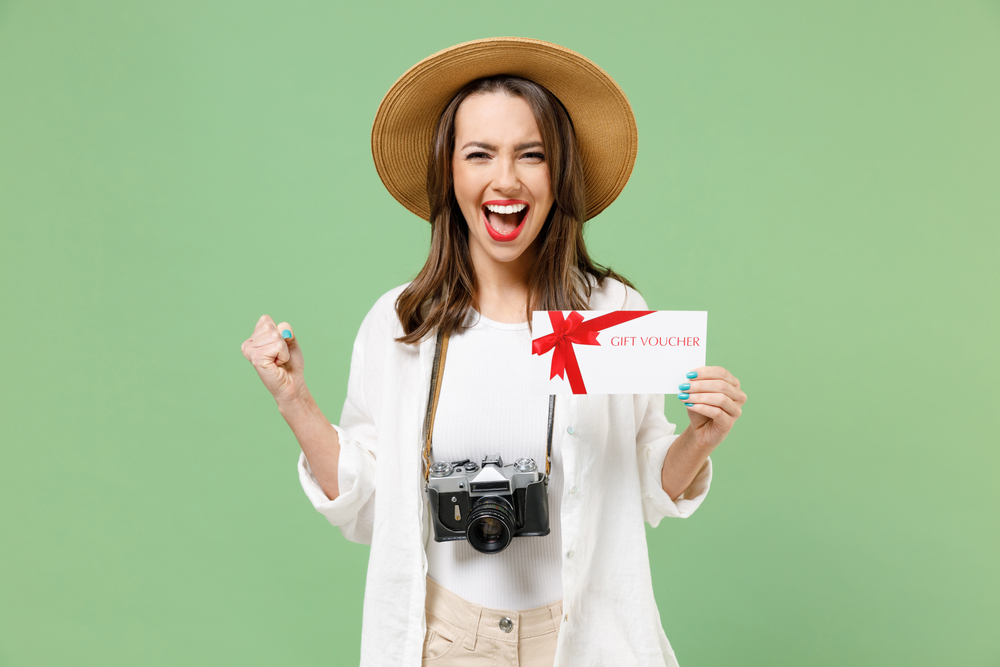 Traveler overjoyed tourist woman in clothes hat hold gift voucher