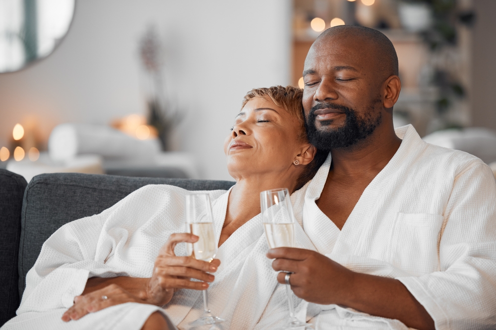 Mature couple, bonding and champagne on spa date, romantic retreat or resort holiday for marriage anniversary celebration.