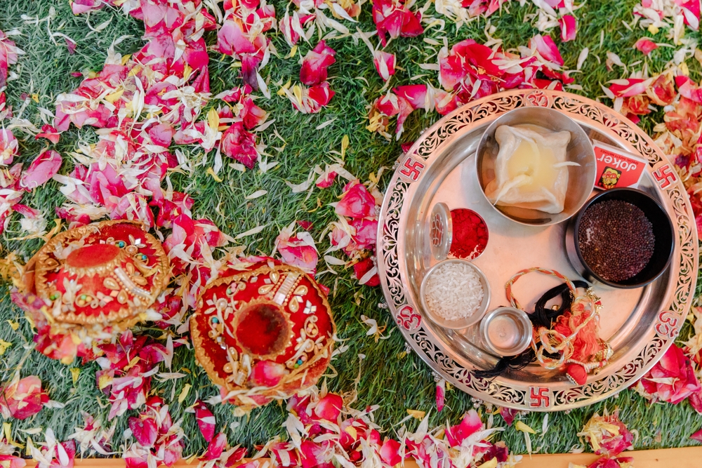 New Delhi, India. 28 Feb 2024, Delhi India. Beautifully Decorated Pooja Thali for diwali celebration to worship, huldi or turmeric powder and kumkum, flowers, scented sticks in brass plate on orange