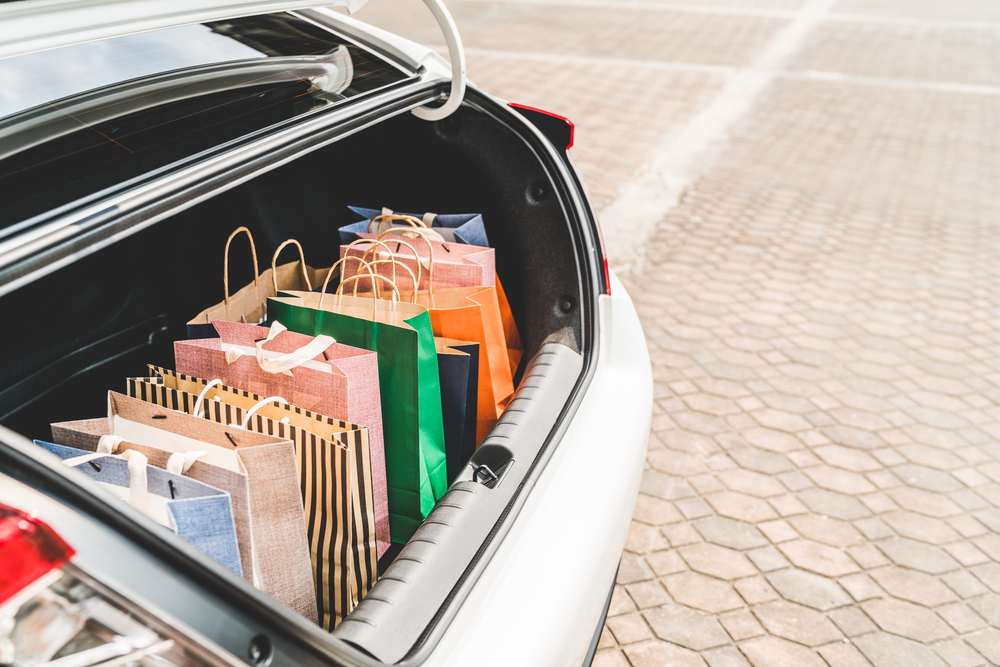 Shopping bags in car trunk or hatchback, with copy space.