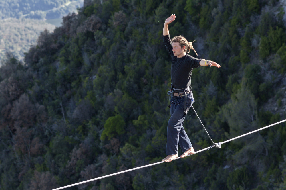 Man practicing highline in Tavertet, Spain on April 13, 2013. Highline is a balance sport that consists walking through a rope clamped between two points and great height below.