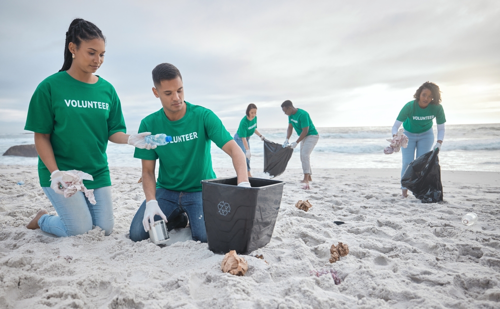 Collaboration, charity and recycling with people on beach for sustainability, environment and eco friendly. Climate change, earth day and nature with volunteer and box for help, energy and pollution