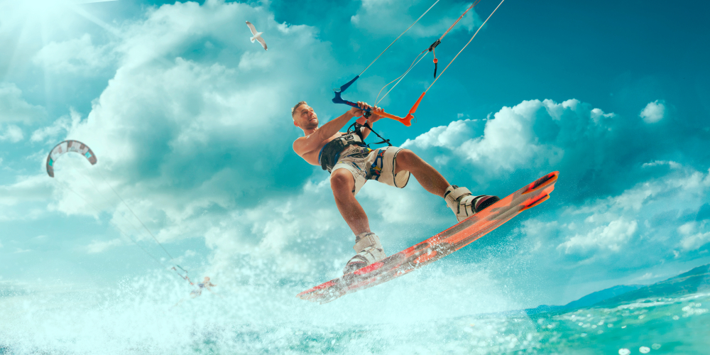 Kitesurfing. Man rides on kite on waves