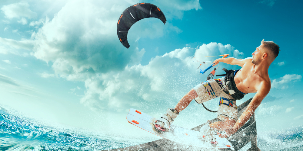 Kitesurfing. Man rides on kite on waves