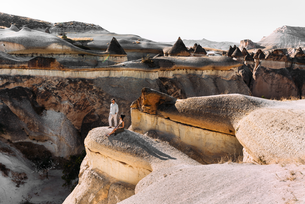 Couple in love in the mountains at sunset. Tourists on the tour. A couple in love travels to Turkey, Cappadocia. Man and woman at sunset.