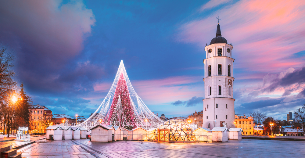 Vilnius, Lithuania. Christmas Tree On Background Bell Tower Belfry Of Vilnius Cathedral At Cathedral Square In Evening New Year Christmas Xmas Illuminations. Unesco World Heritage Site. Altered Sky.