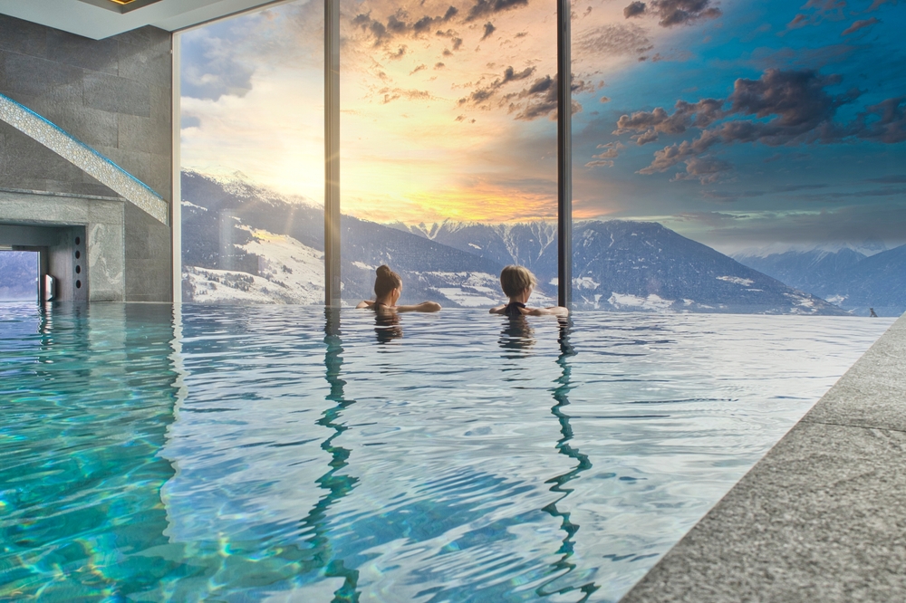 Women enjoying the panoramic view from the pool in the alps