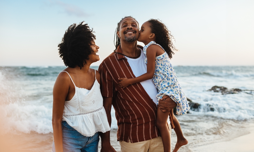 A happy Brazilian family shares a joyous moment together on a beautiful beach during their vacation.