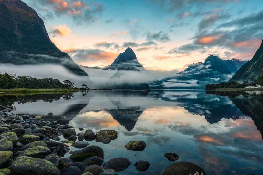 Mysterious landscape of Milford Sound or Rahotu with Mitre peak in foggy on the lake during the morning at Fiordland national park, New Zealand