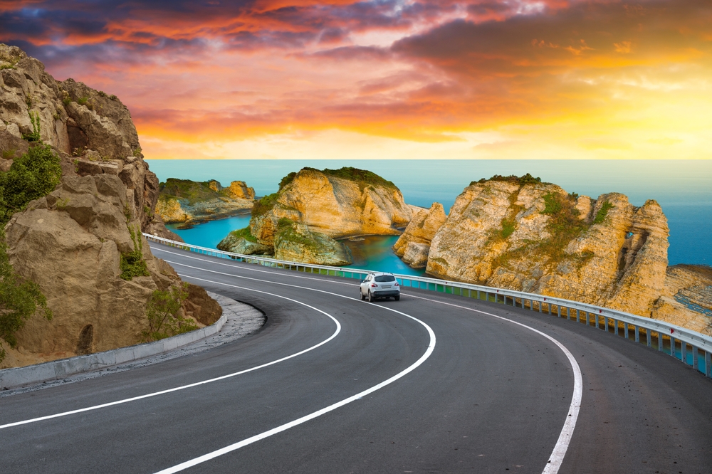 highway landscape at colorful sunset. road view on mediterranean coast of spain.