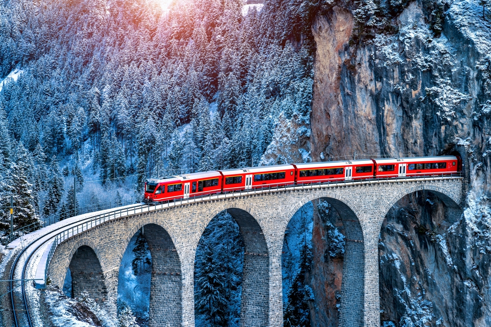 Aerial view of Train passing through famous mountain in Filisur, Switzerland. train express in Swiss Alps snow winter scenery.