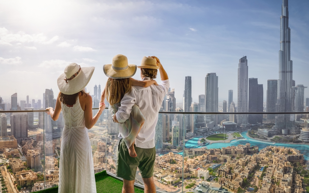 A elegant family on a city break vacation enjoys the panoramic view over the skyline of Dubai, UAE