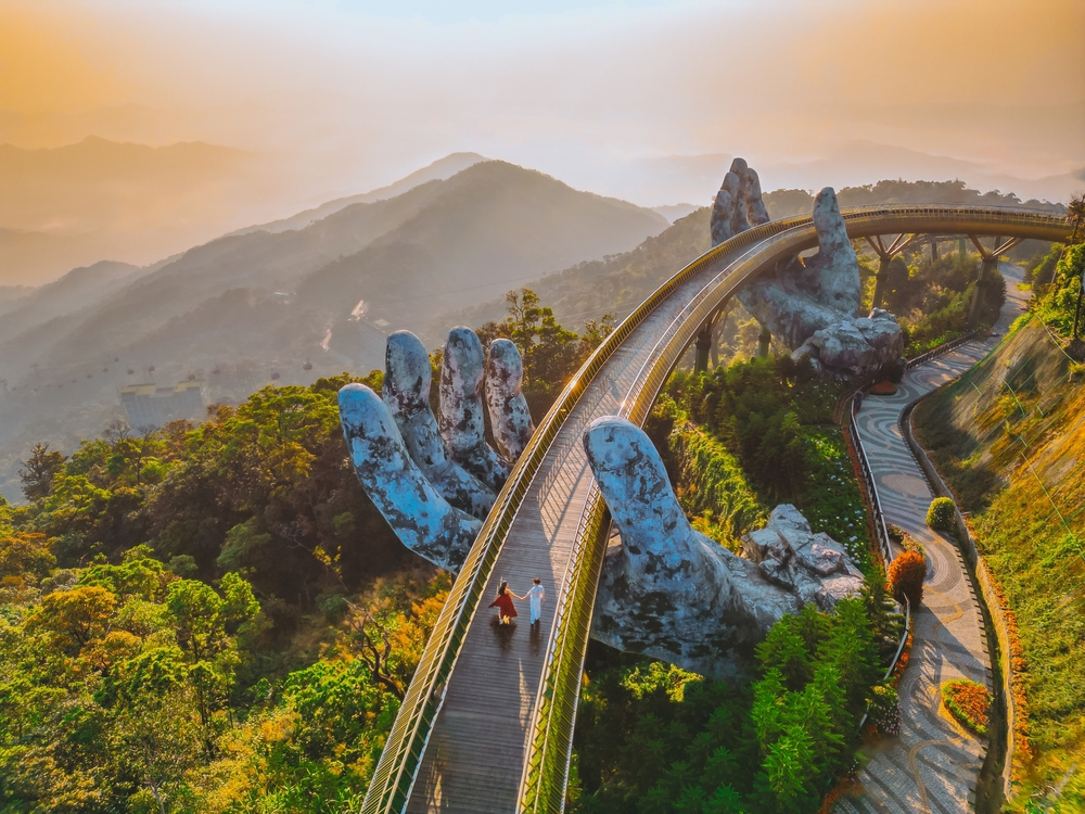 Young traveler Couple Walking on the Golden Bridge in Bana hills, enjoying the morning , Danang Vietnam