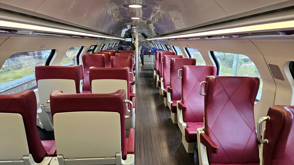 Interior of NS (Nederlandse Spoorwegen) Intercity train business seats. First class ticket with comfortable, luxury red chairs.