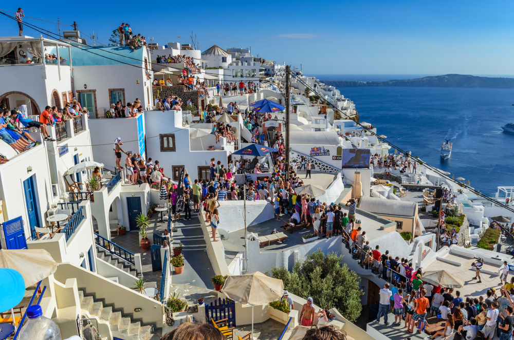 Tourists and visitors wait to see a unique parkour show from athlets around the world in Santorini Island, Greece. 