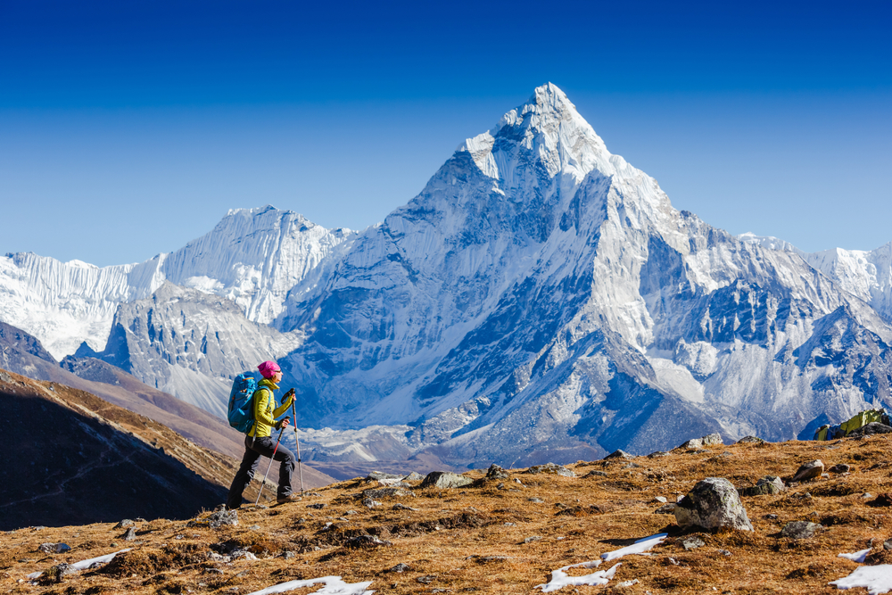 Woman Traveler hiking in Himalaya mountains with mount Everest, Earth's highest mountain. 