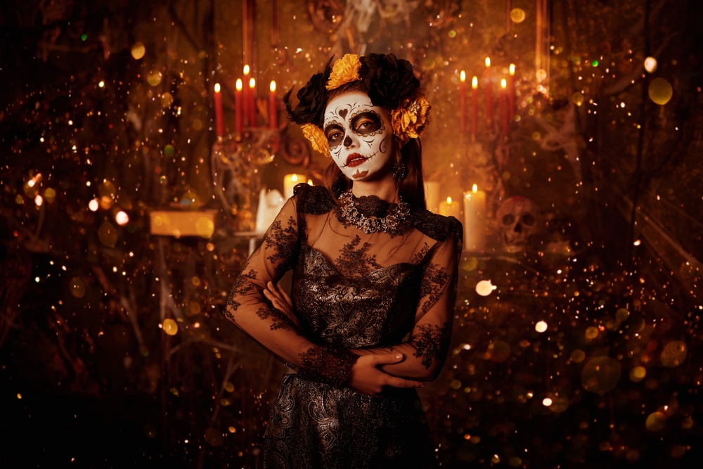 Halloween. Day of The Dead. Charming and dangerous Calavera Catrina in an old castle in the light of candles and shining magic lights. Sugar skull girl. Dia de los muertos.