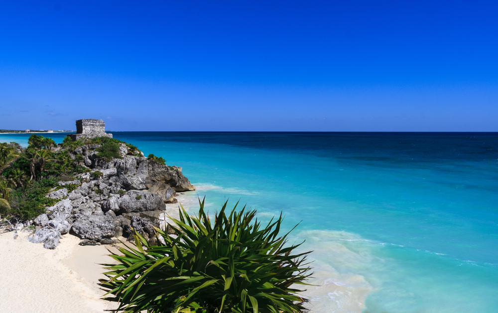 Beautiful beach with turquoise water in Tulum Mexico, Mayan ruins on top of the cliff.