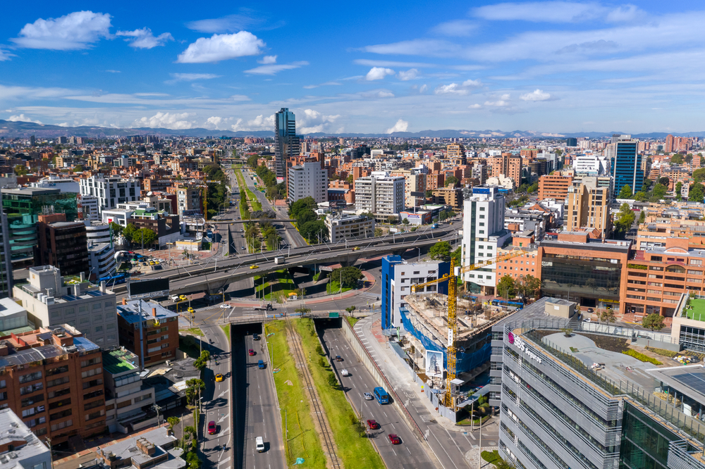 View from a drone of an avenue in a residential and office area where there is a roundabout and a road junction that is relatively empty due to the pandemic. 