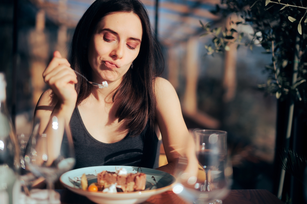 Woman Unhappy with Her Dessert Eating in a Restaurant. Girl feeling disappointed on a sweet cake with ice cream dish