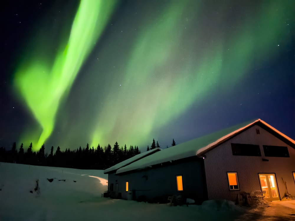 Aurora borealis northern lights at night over a house