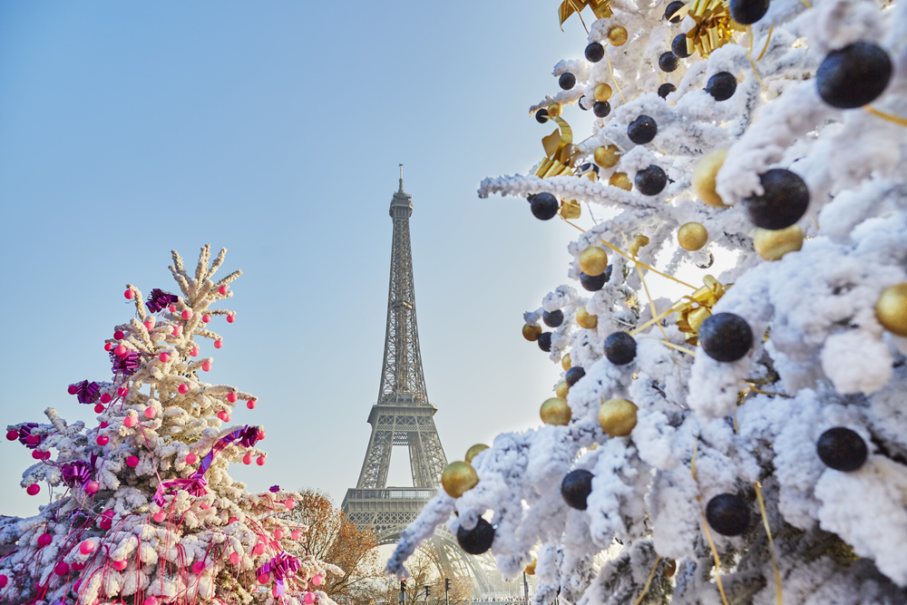 Decorated Christmas trees covered with snow near the Eiffel tower in Paris, France