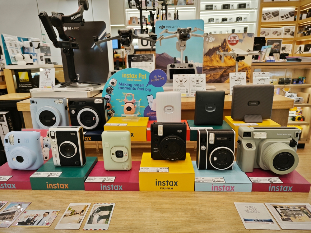 Different instax camera models,colors and sizes display on one of the outlet store for sale at the Queen Bay Mall, Georgetown.