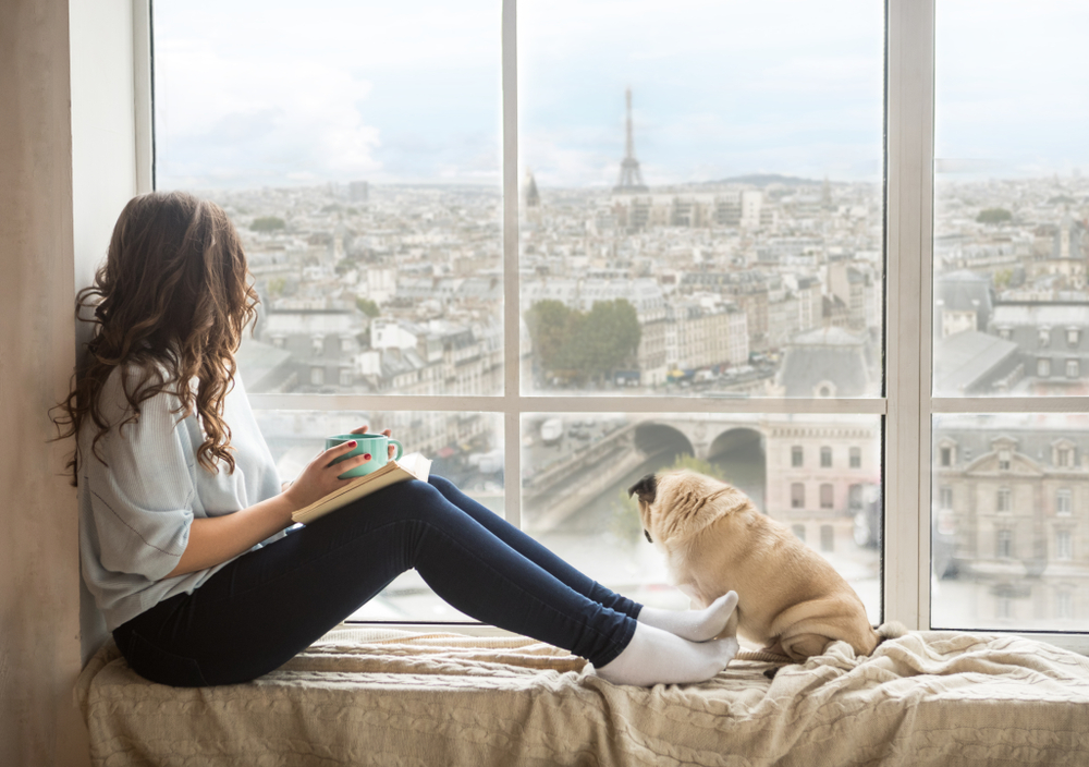 Beautiful long haired woman enjoying Paris France view outside the window