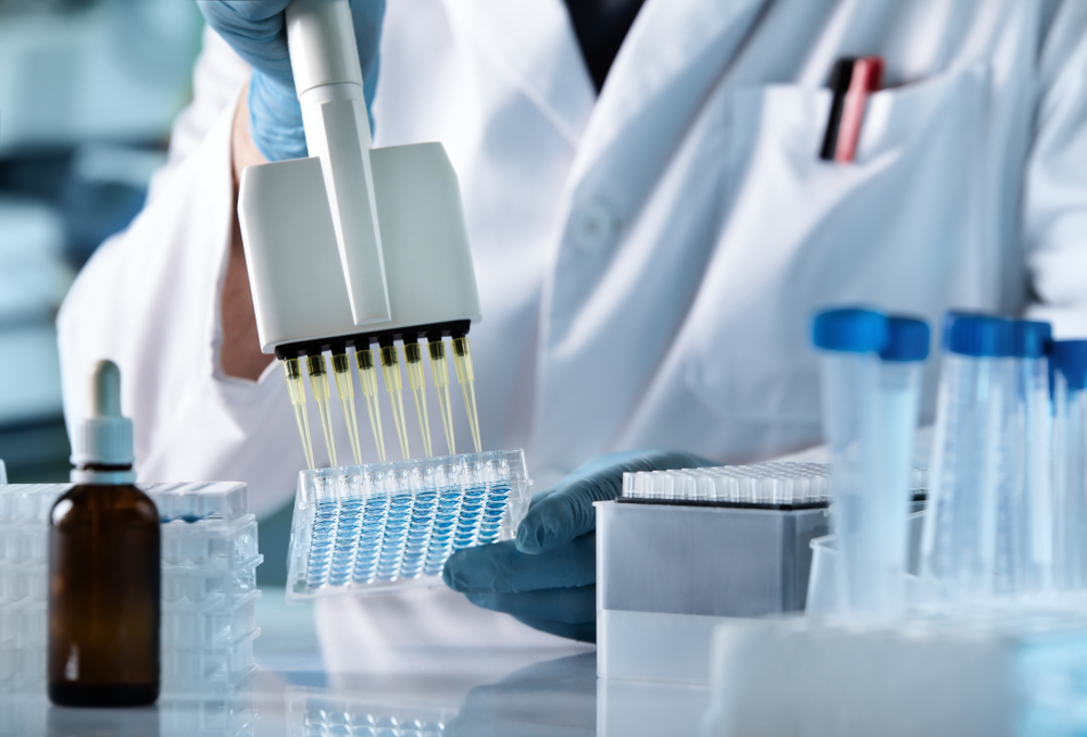 hands of scientist working with multichannel pipette and multi well plates.