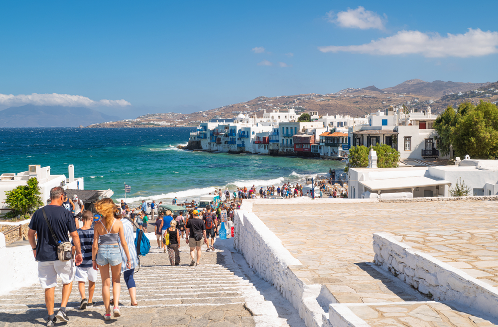 A crowd of tourists goes to the Little Venice area of the Chora old village 