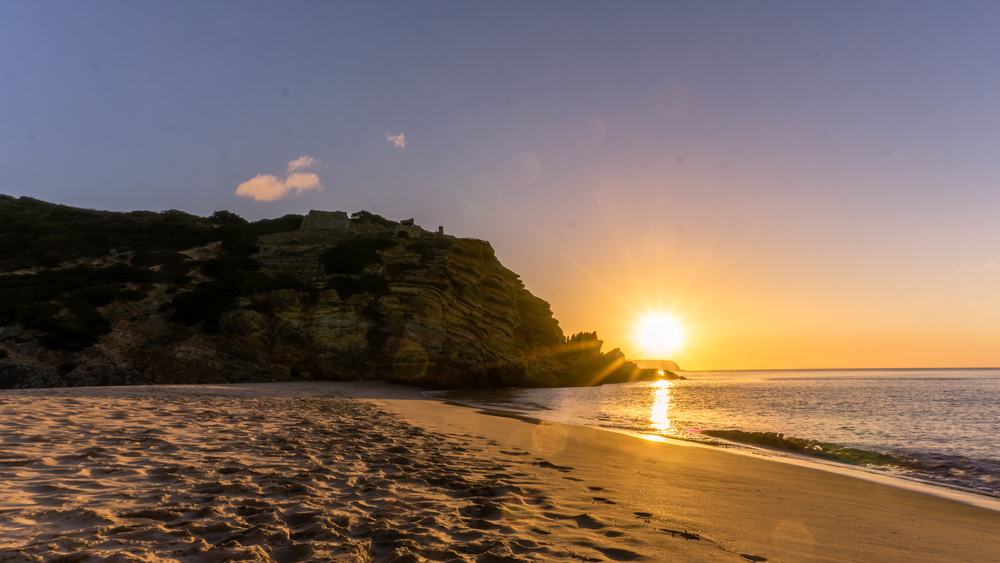 Colorful sky at morning with rock at sunrise at praia da Figueira, Portugal