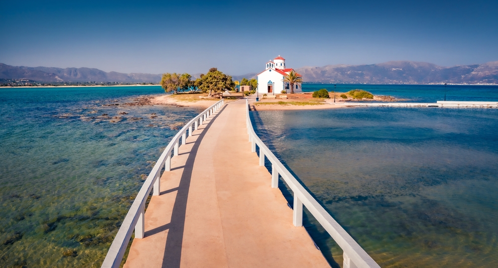 Exciting summer view of Saint Spiridon church in Elafonisos port. Captivating morning seascape of Mediterranean Sea. Perfect outdoor scene of Elafonisos island, Greece, Europe.