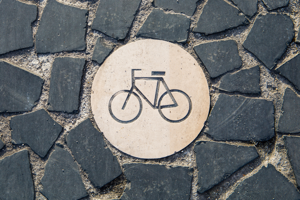 Bicycle symbol engraved in the paving of a bike lane. Cycle path sign in Lisbon Portugal. Zero emission transportation and pollution control in a big city.