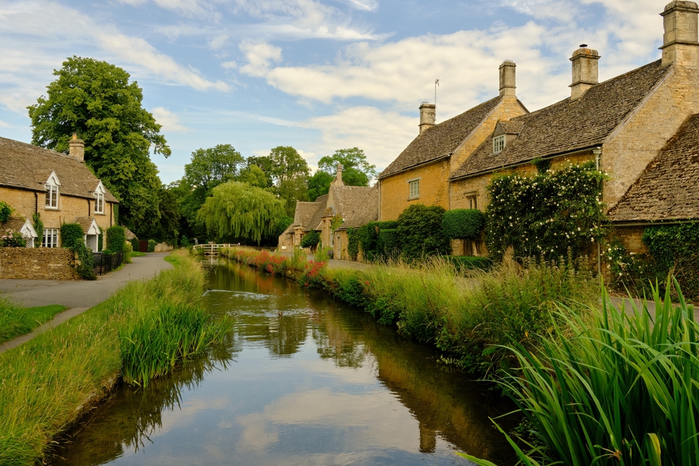 Traditional English stone cottages along the picturesque River Eye in Bourton on the Water, Cotswolds, Gloucestershire, England, UK