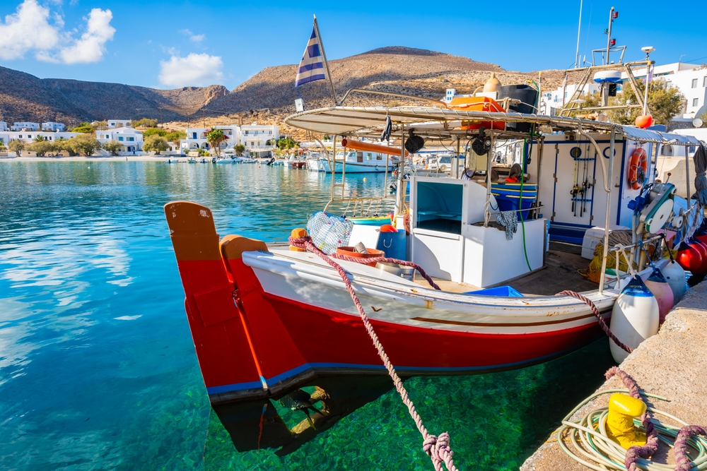 Traditional fishing boat anchoring in Karavostasis port, Folegandros island, Cyclades, Greece